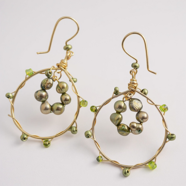 Close up of gold hoop earrings with green beads