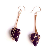 Purple stone earrings with gold wire wrapping on a white background