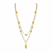 Gold necklace with yellow beads on a white background