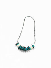 Turquoise black and white wood necklace on white background.