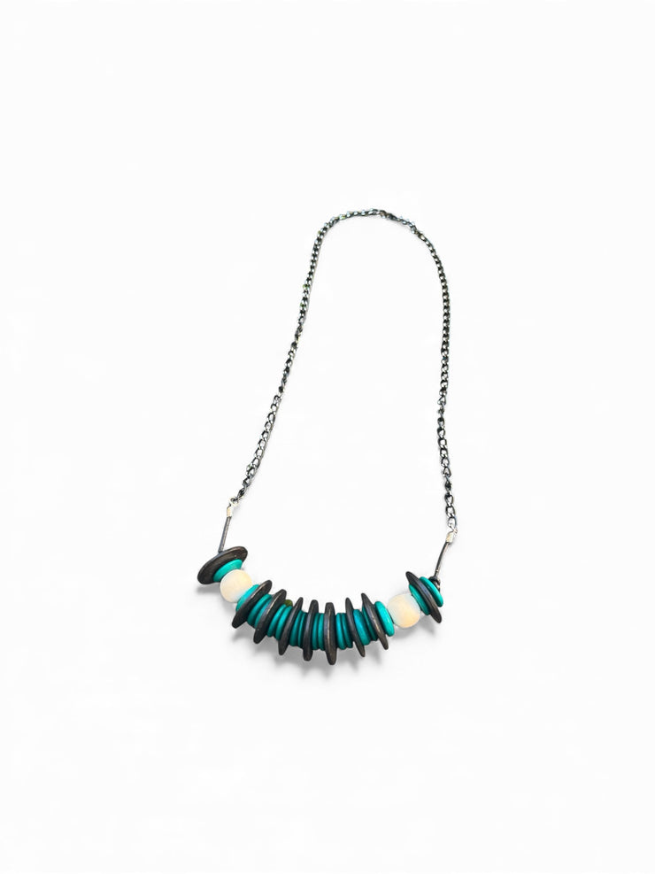 Turquoise black and white wood necklace on white background.