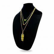 Necklace with a recycled green glass pendant on a black mannequin bust against a white background