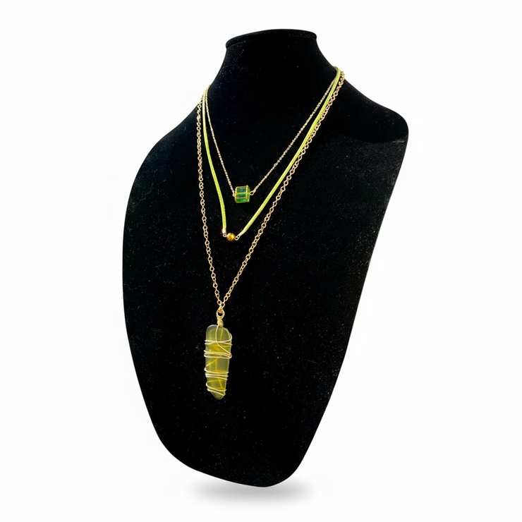 Necklace with a recycled green glass pendant on a black mannequin bust against a white background