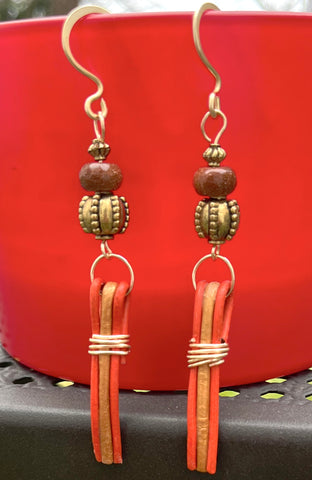 Goldstone Lantern earrings made with gold and orange faux leather cord.  Gold tone spacers and goldstone beads complete the look. 