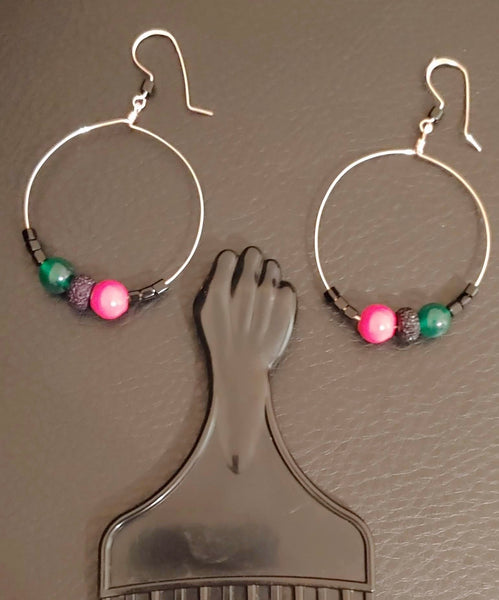 Angela Davis hoop Rose gold colored hoop earrings with red, black, and green beads