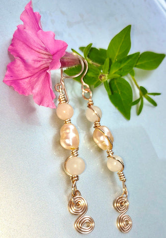 Pink coral beads and pink pearls wrapped with rose gold tone wire.